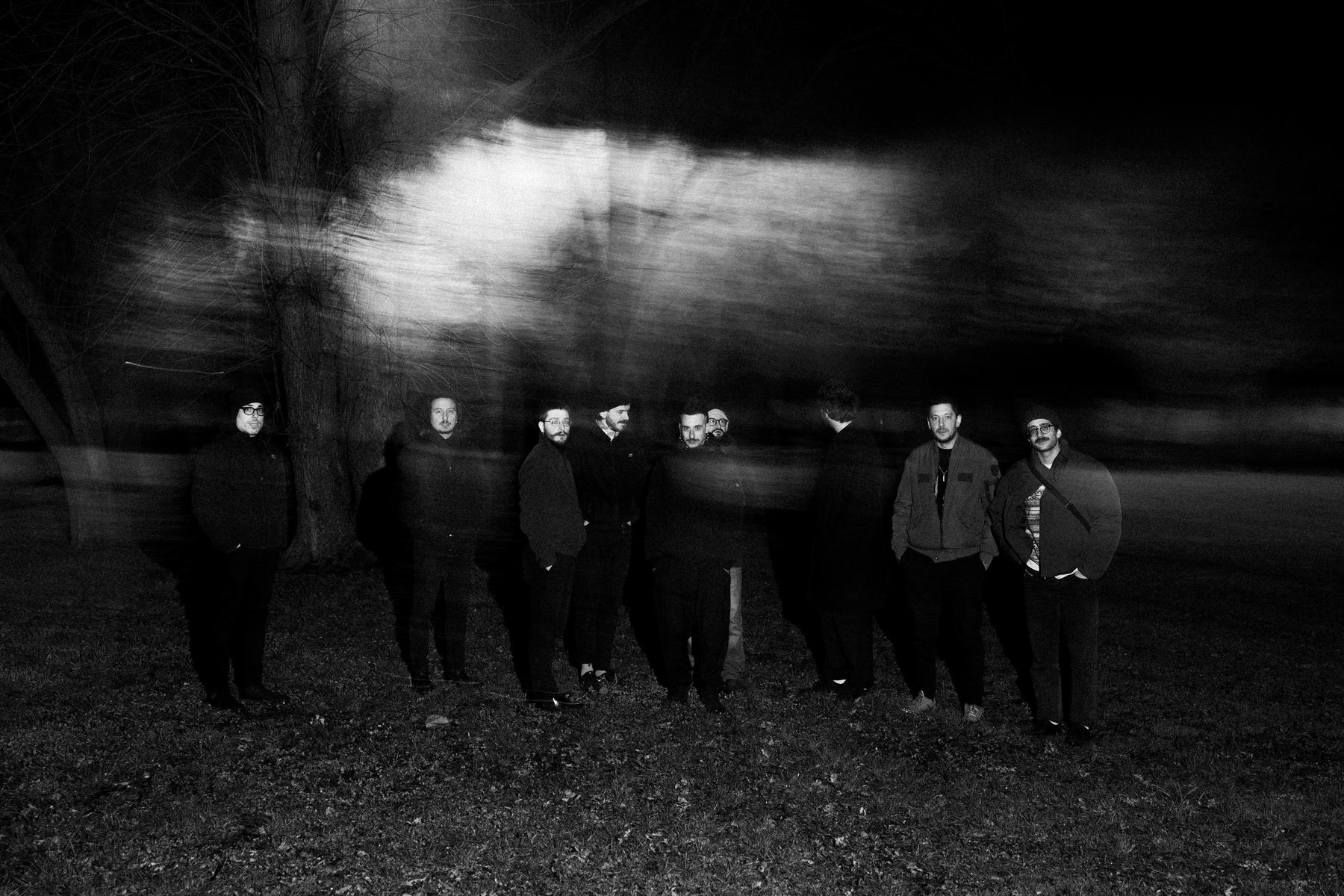 The ten members of Goodbye, Kings standing in a park at night
